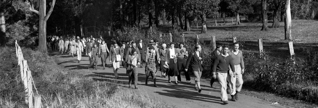 black and white photo of people dressed for a picnic on a hike