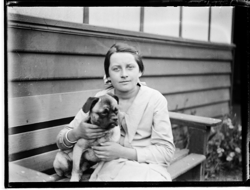 black and white photo of a woman holding a dog
