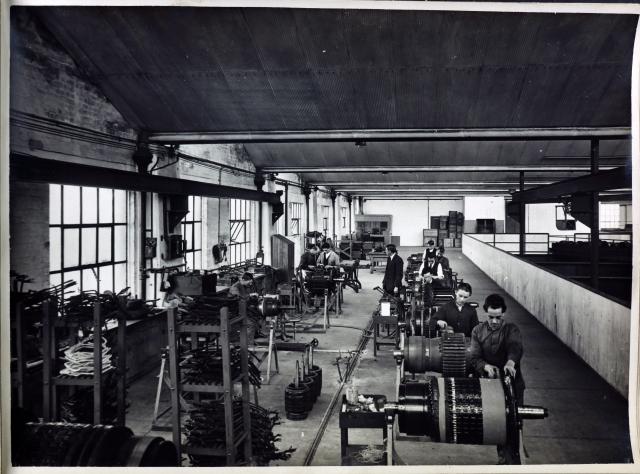 black and white image of men working in a workshop with machinery