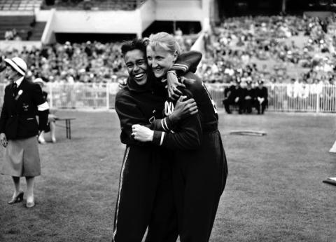 black ans white image of 1956 women long jump olympians embracing.