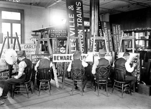 black and white image of sign writers at work.