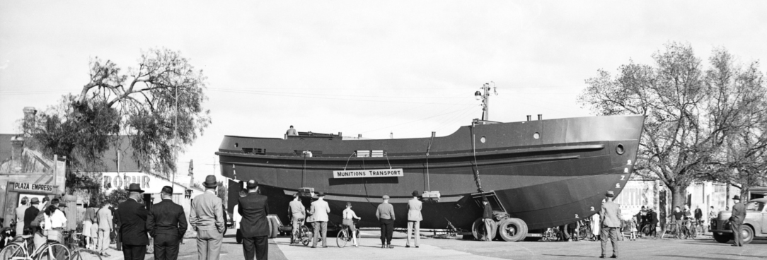 Black and white photo of a boat being moved on a road