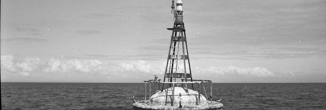 black and white photo of a buoy on the ocean