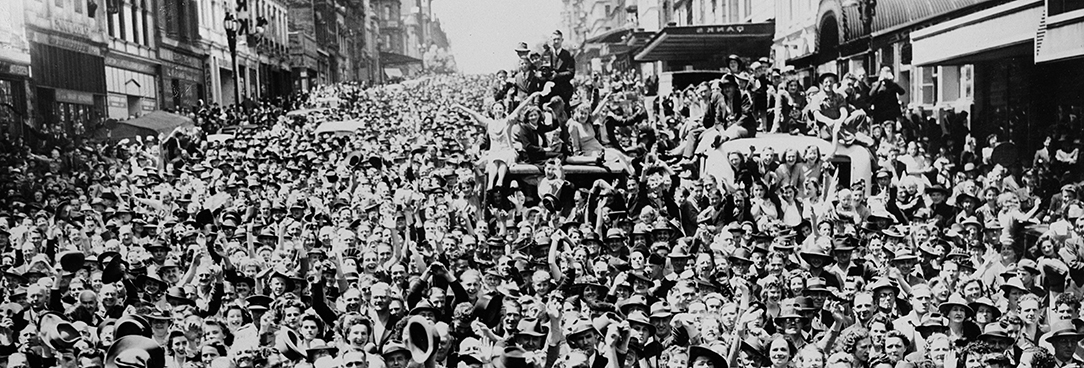 B692 Crowds gathered (Melb) to celebrate peace. Black and white photo of crowds filling the streets of Melbourne CBD to celebrate the end of WW2