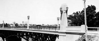Black and white photo of a bridge over a river