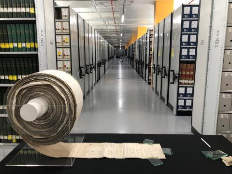photo of a huge rolled up scroll petition in the middle of a archive 
