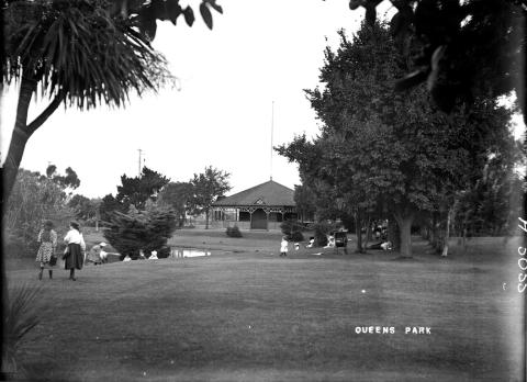 black and white photo of people walking through a park