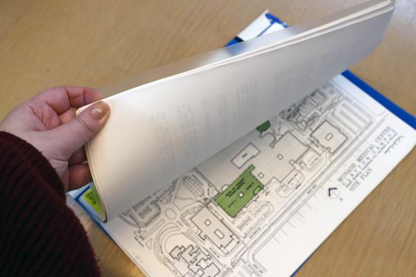 someone flipping through a book of plans